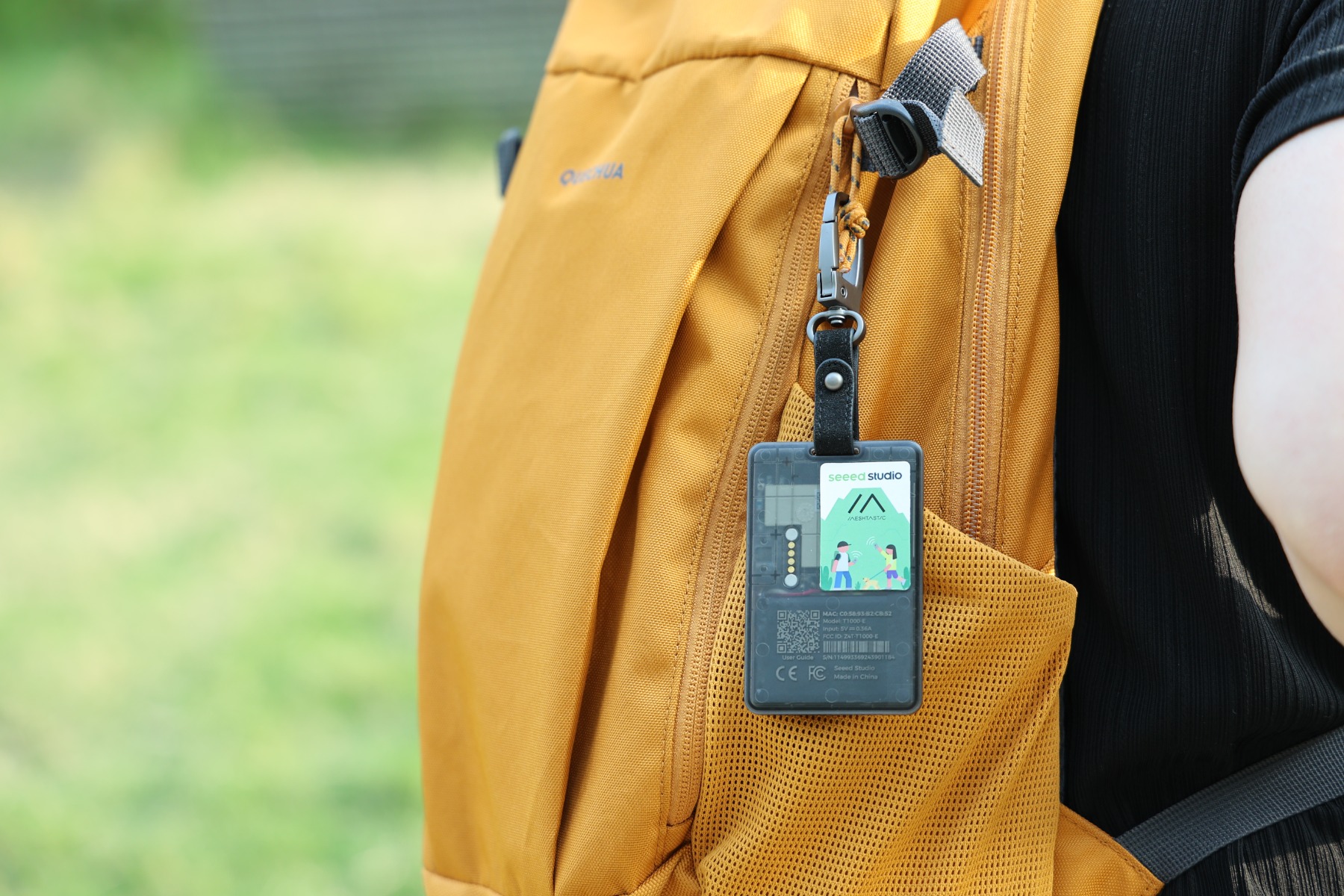 SenseCAP T1000-Eを手に持ち、スマートフォンでMeshtasticアプリを表示